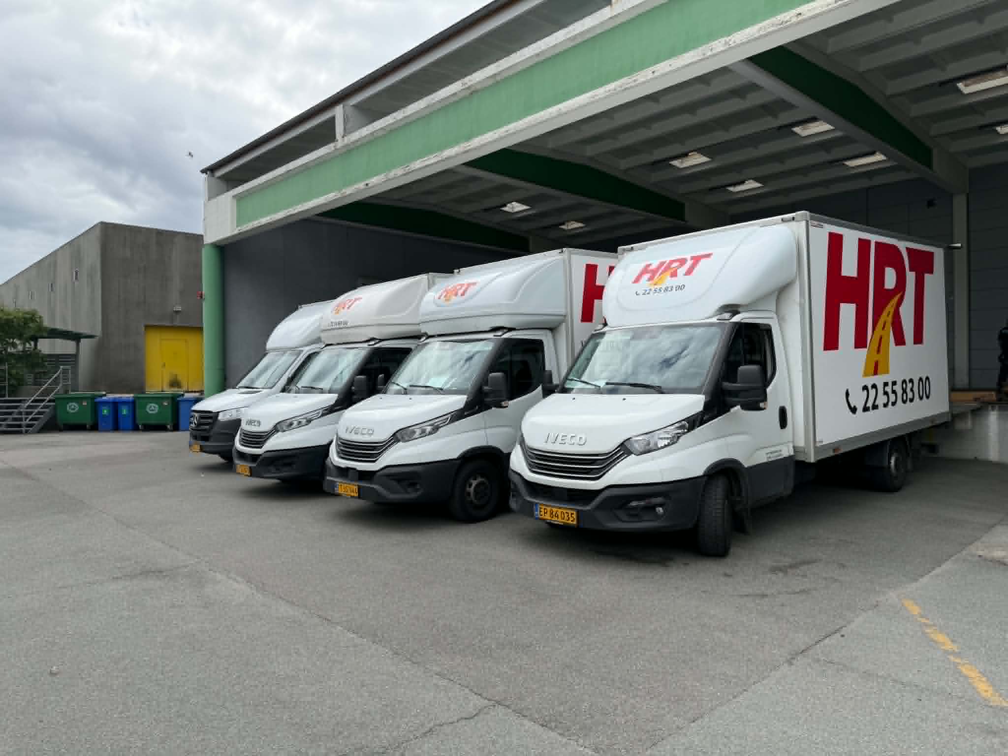 HR Transport varebiler parkeret ved en læsserampe.